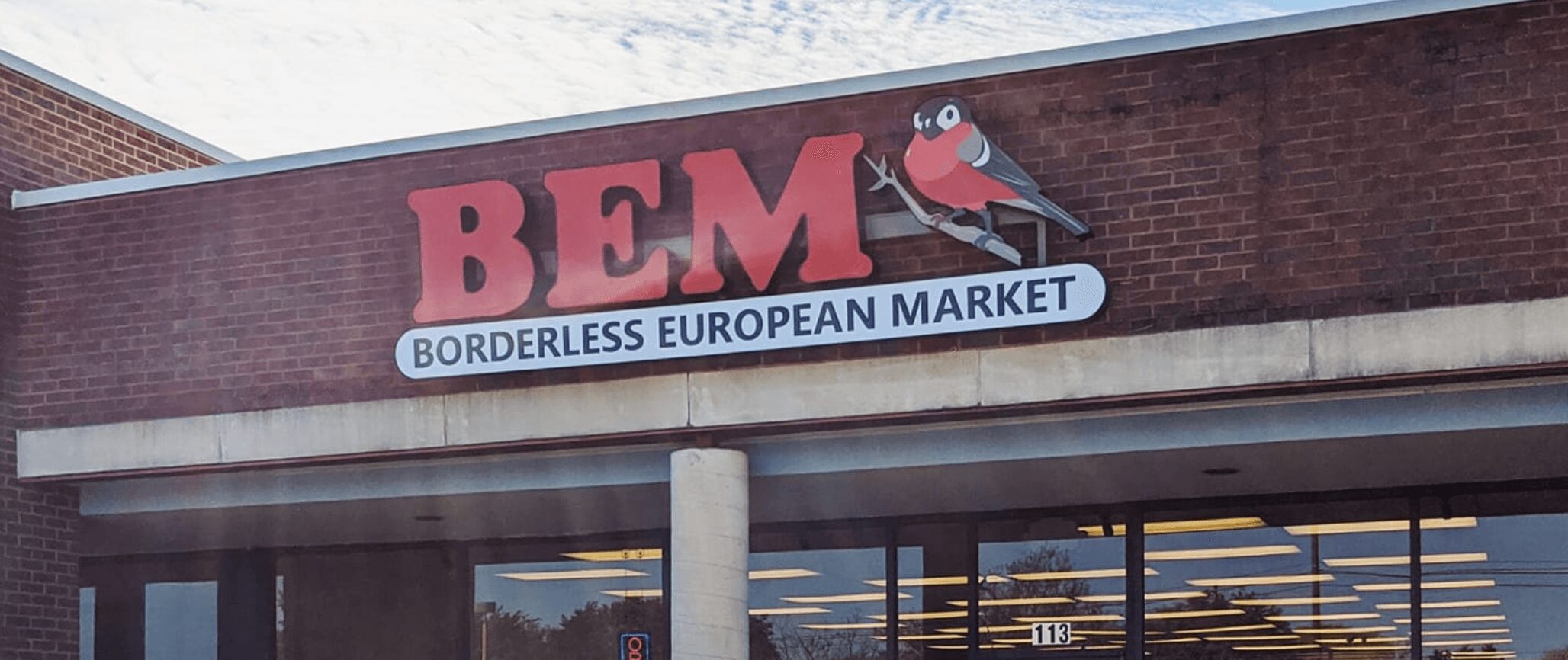Storefront sign reads BEM Borderless European Market with a cartoon character holding a shopping bag.