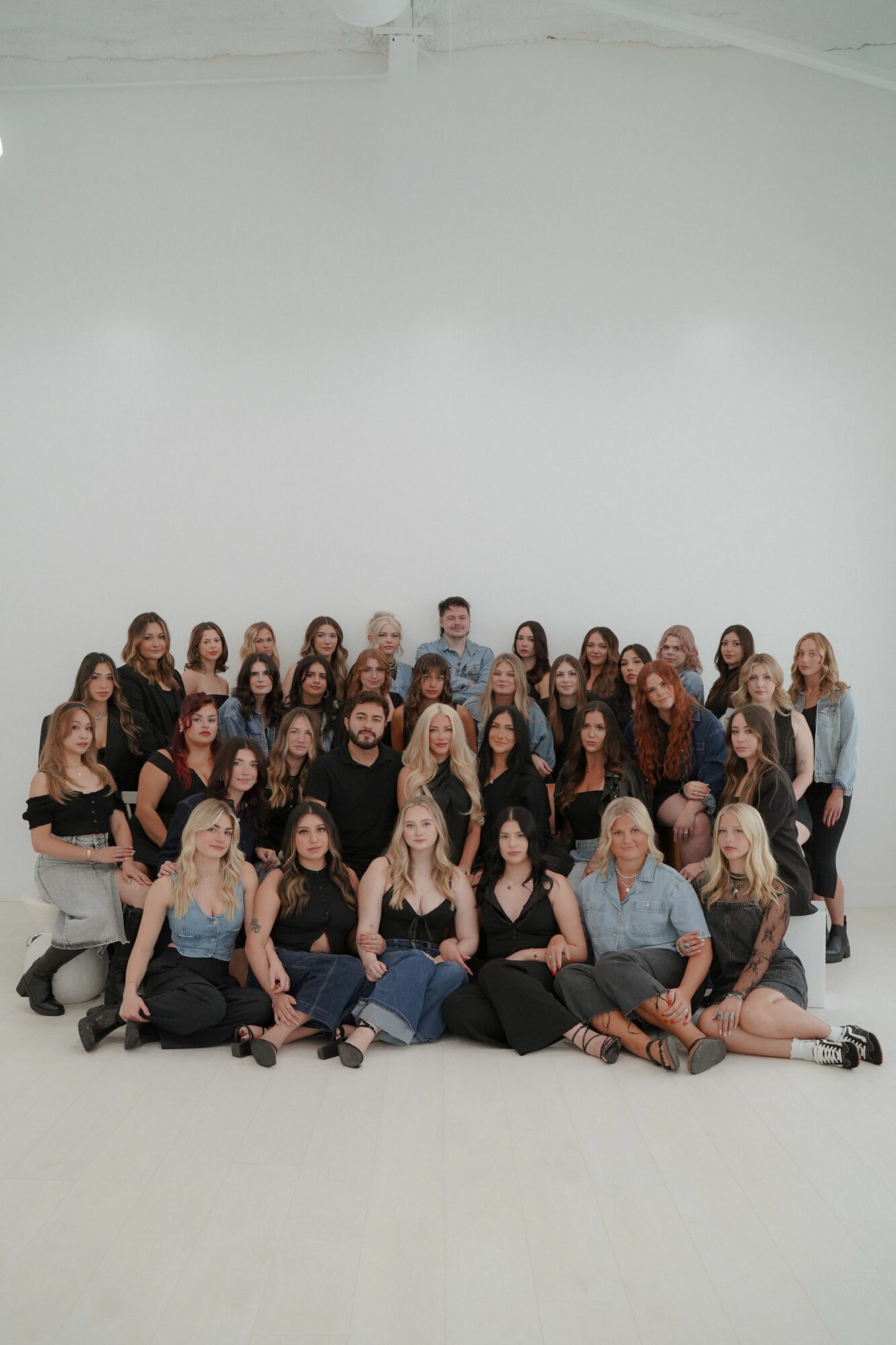 Group of people posing together in a studio with a plain white background.