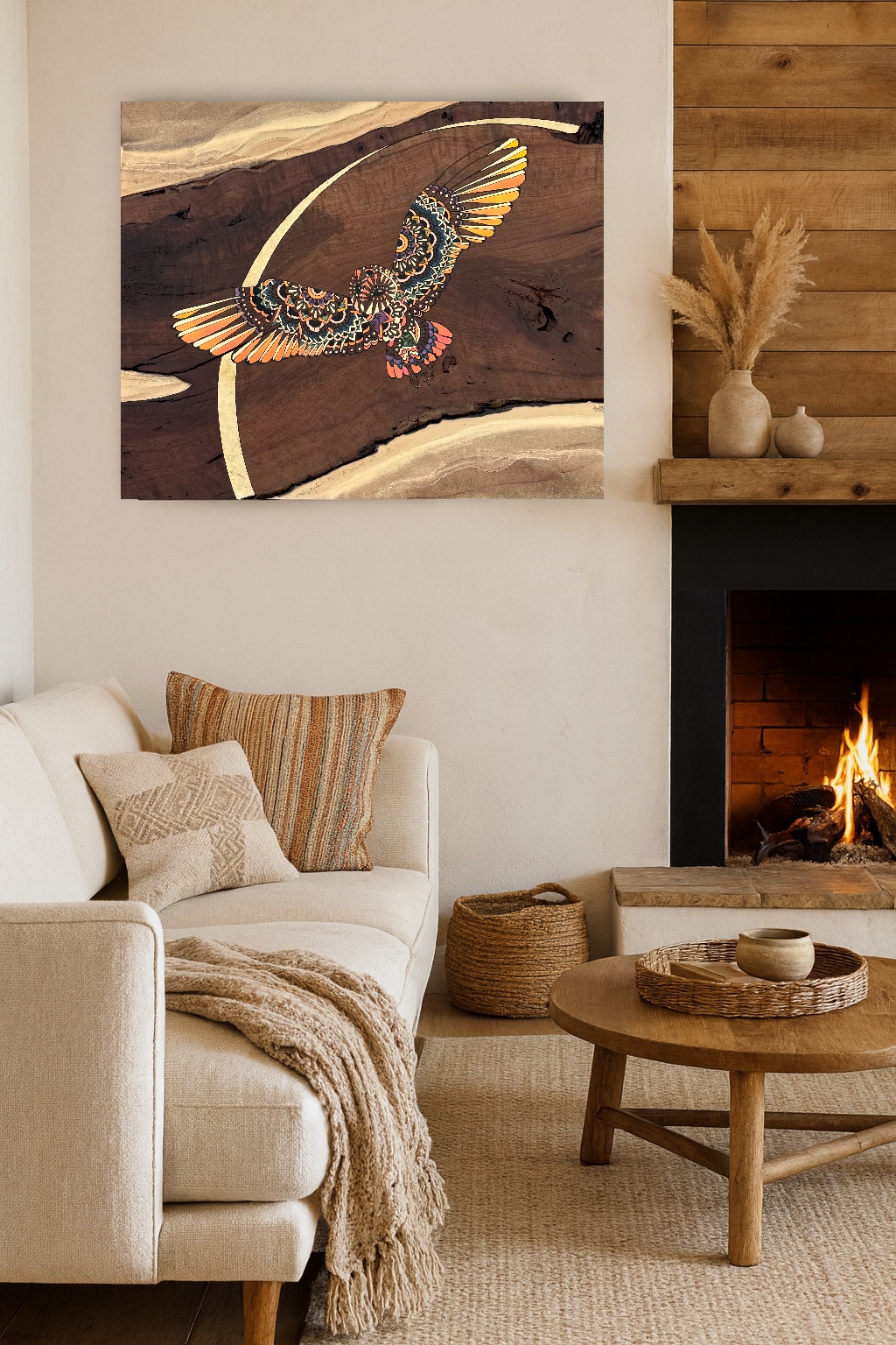 Living room with a white sofa, striped pillows, a wooden coffee table, and a fireplace with a fire, wall art of an eagle, and a vase with dried plants.