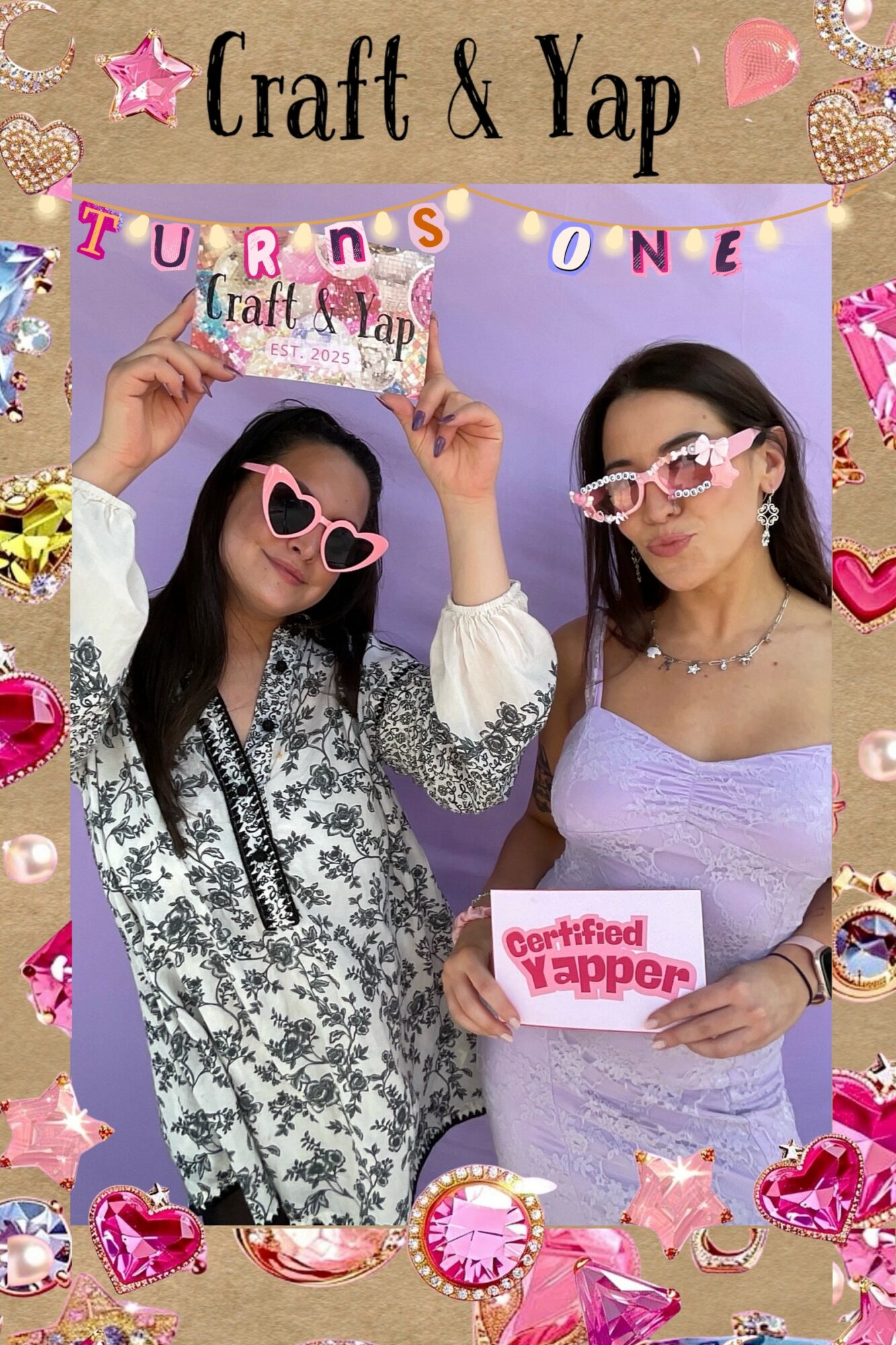 Two women wearing glasses and holding signs, celebrating a craft event with colorful decorations and stickers.