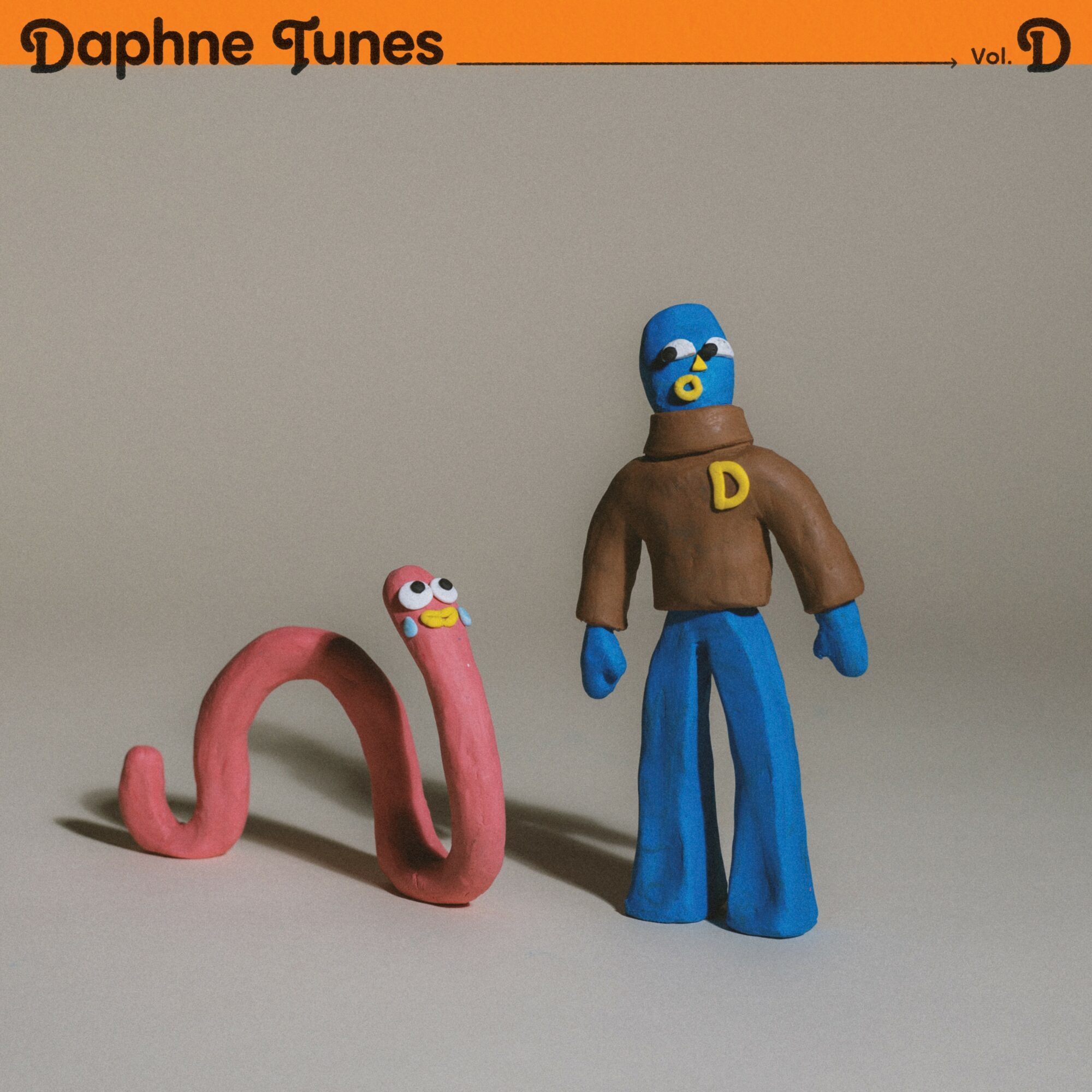 Clay figures of a blue character with a brown shirt and a pink snake with eyes, on a plain background.