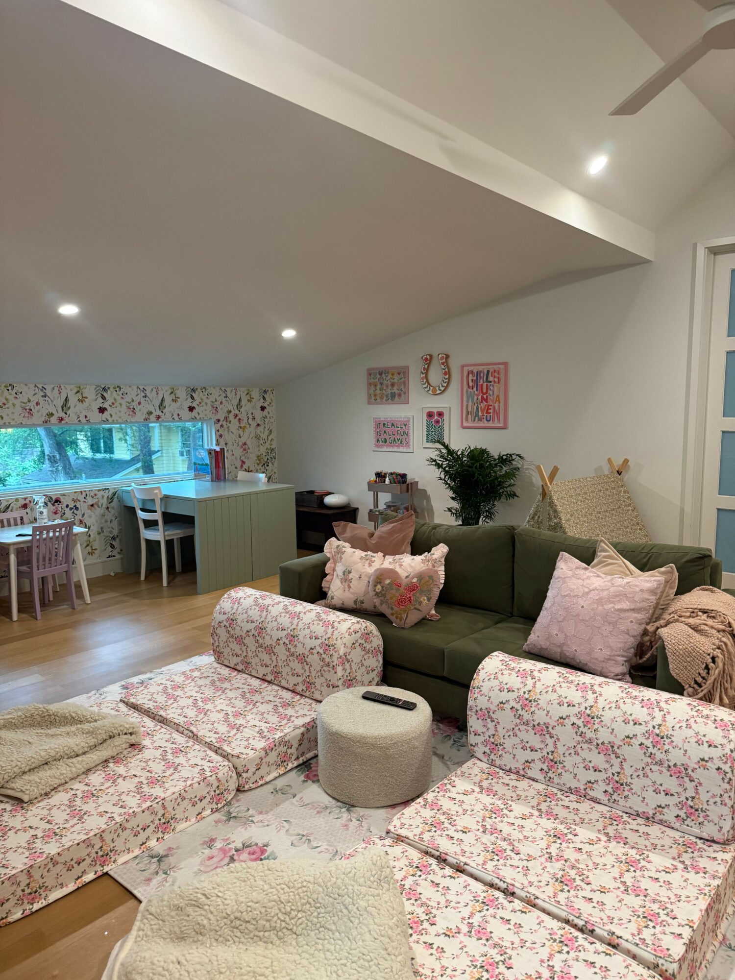 Living room with sofa, cushions, coffee table, and a fish tank visible through a window, viewed from the side.