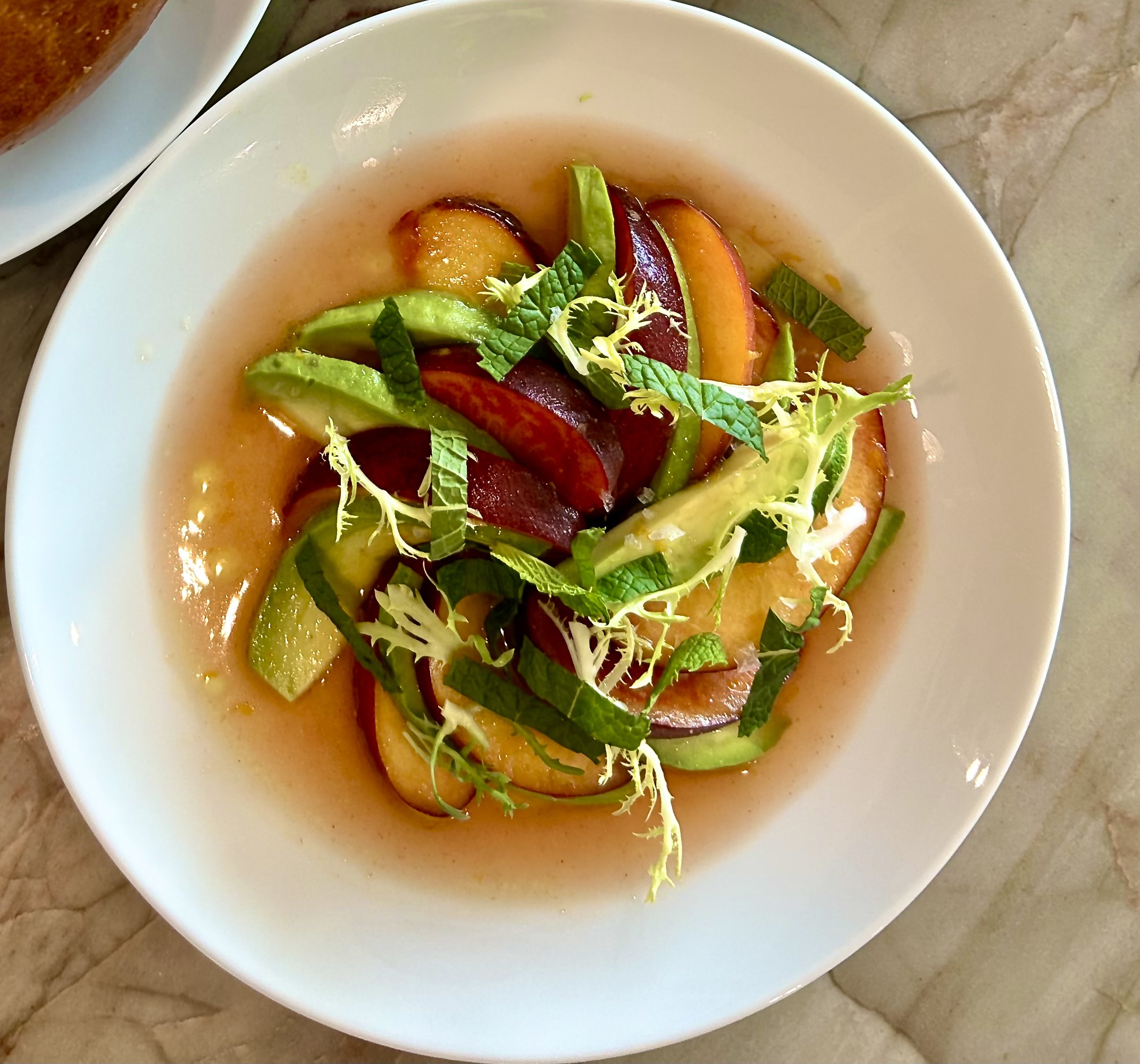 Fresh mixed salad with sliced cucumbers, tomatoes, and leafy greens in a light dressing.