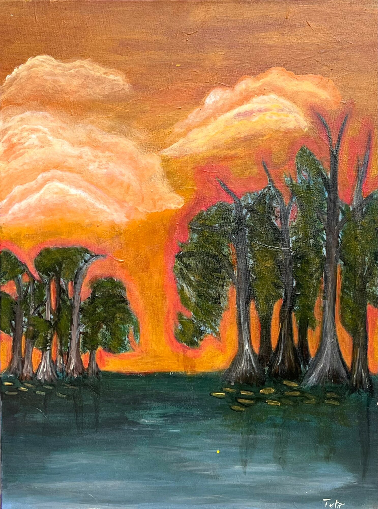 Sunset over a body of water with trees silhouetted against an orange and pink sky.