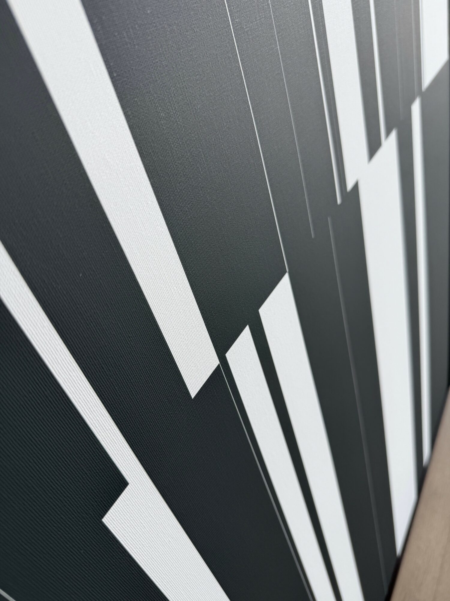Close-up of a black and white geometric patterned surface with vertical lines and shapes.