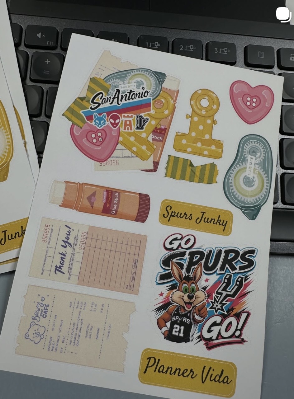 Collection of stickers and tickets on a keyboard, including sports, hearts, a cartoon character, and a planner label.