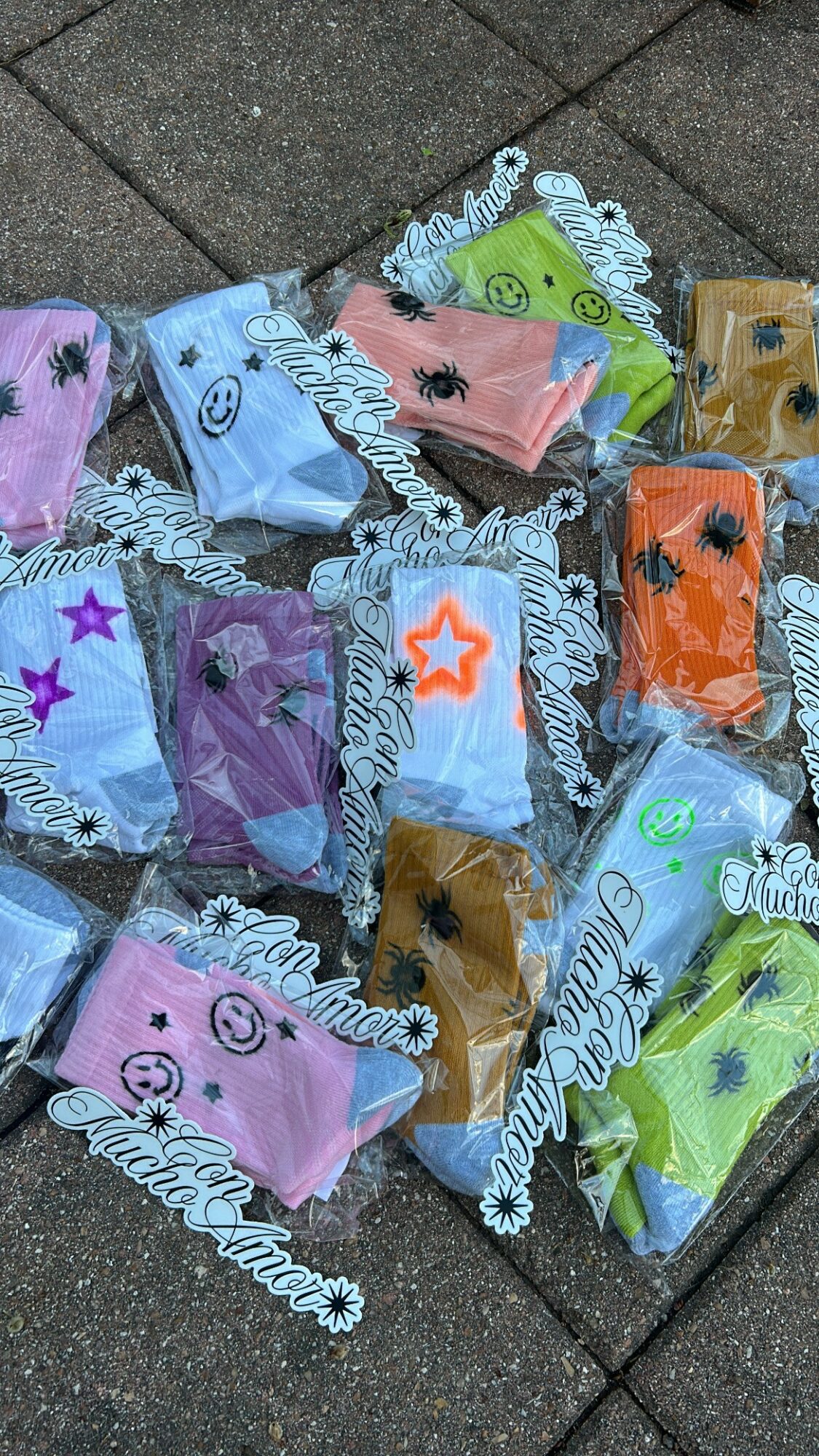 Colorful wrapped candies with smiley faces and star designs on a tiled surface.