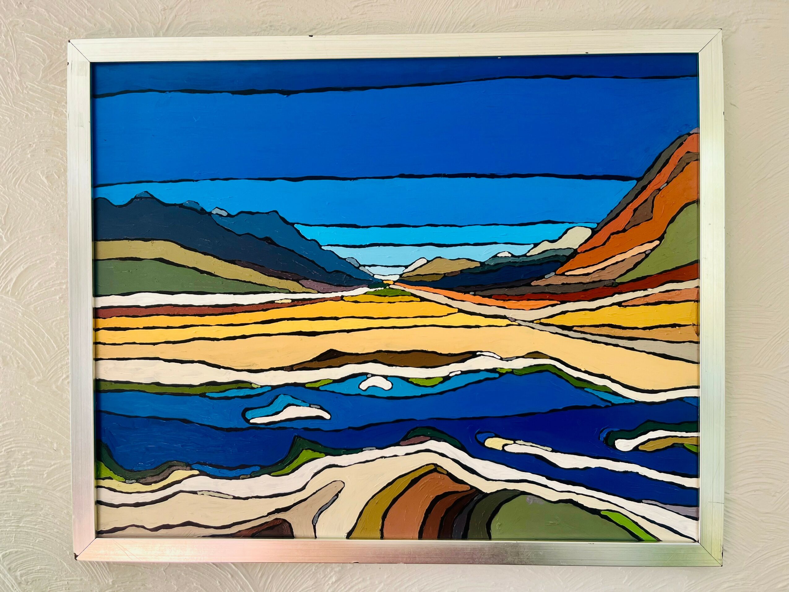 Colorful landscape painting of mountains, sky, and water with vibrant horizontal stripes, framed in white.