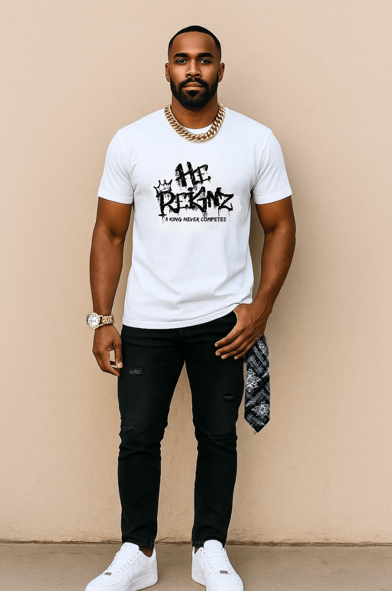 Man standing against beige background, wearing white T-shirt, black pants, white shoes, and gold jewelry.