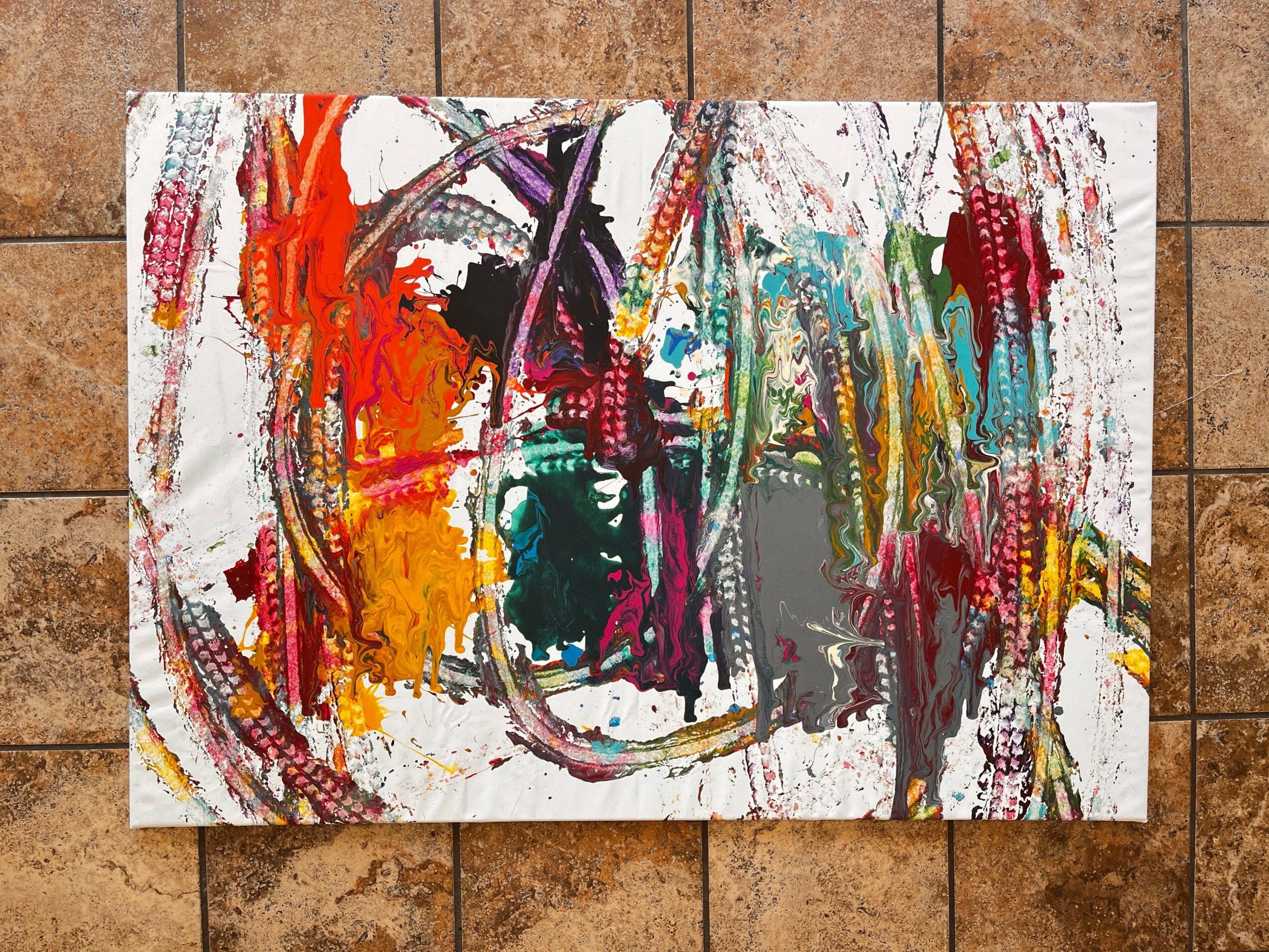 Abstract colorful painting with red, orange, purple, green, and gray strokes on a white background, displayed on a tiled floor.