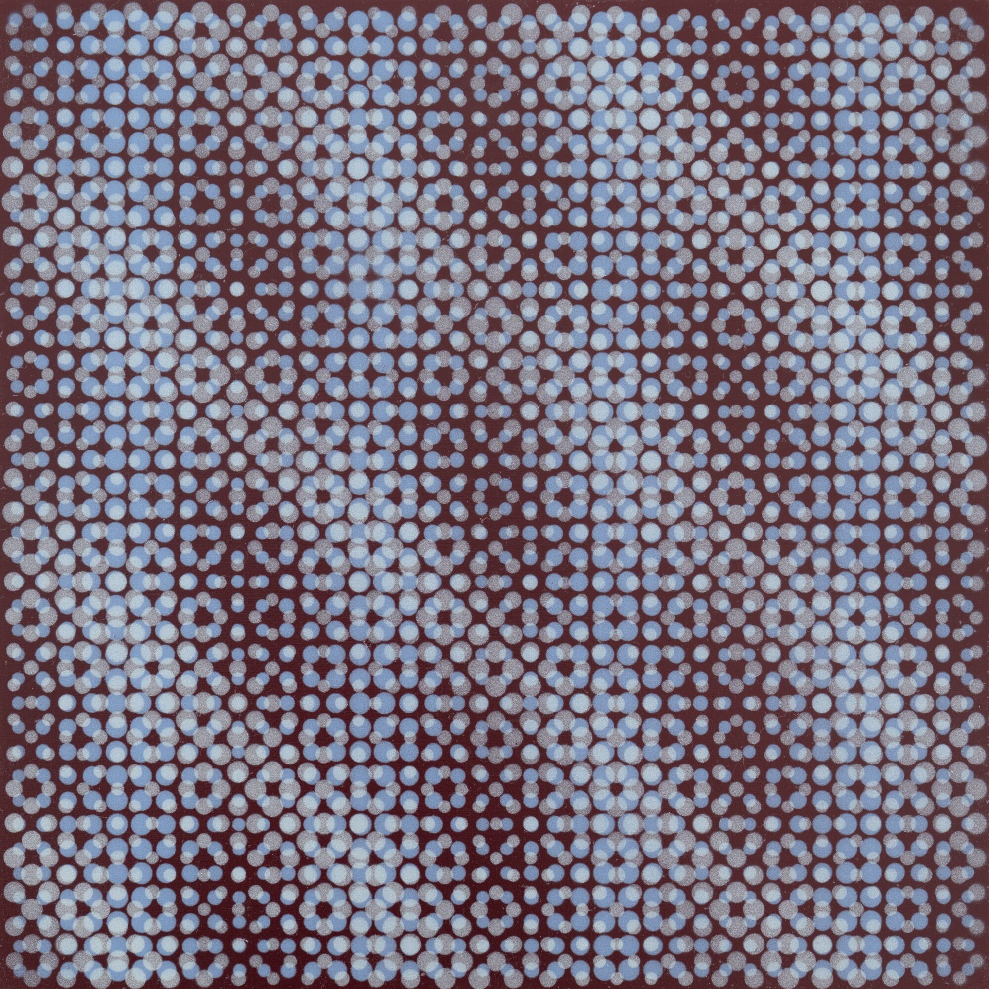 Pattern of small blue and brown circles forming a geometric design on a dark background.
