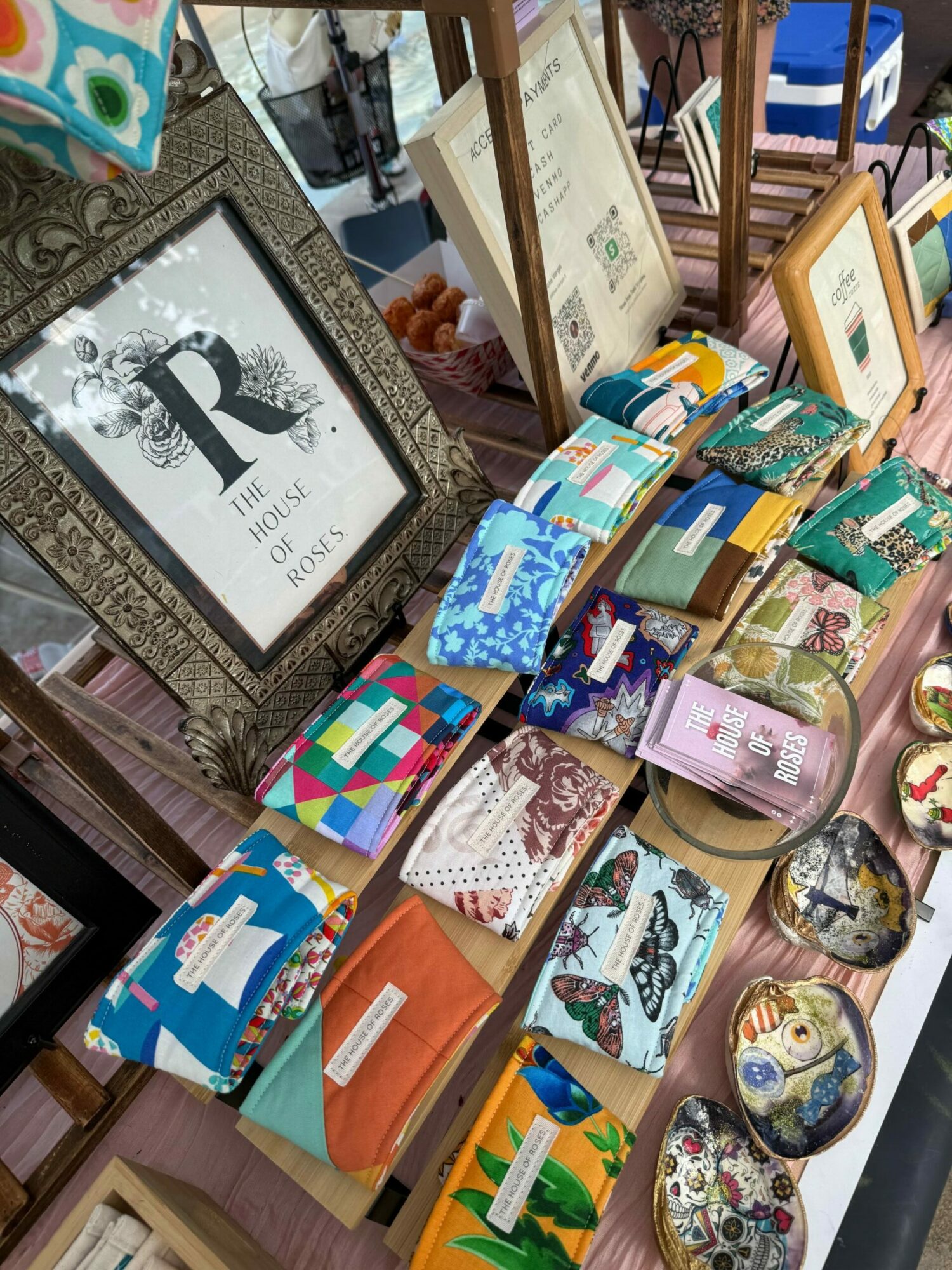 Display of various wallets, pouches, and decorative items on a table, with a framed picture in the foreground.